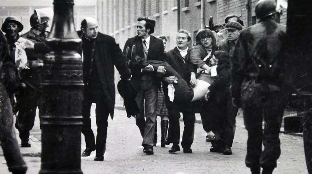 Stanley Matchett (Northern Irish) Bishop Daly waves a blood-stained white handkerchief while men carry away the body of 17-year old Jack Duddy on Bloody Sunday, Derry, 1972